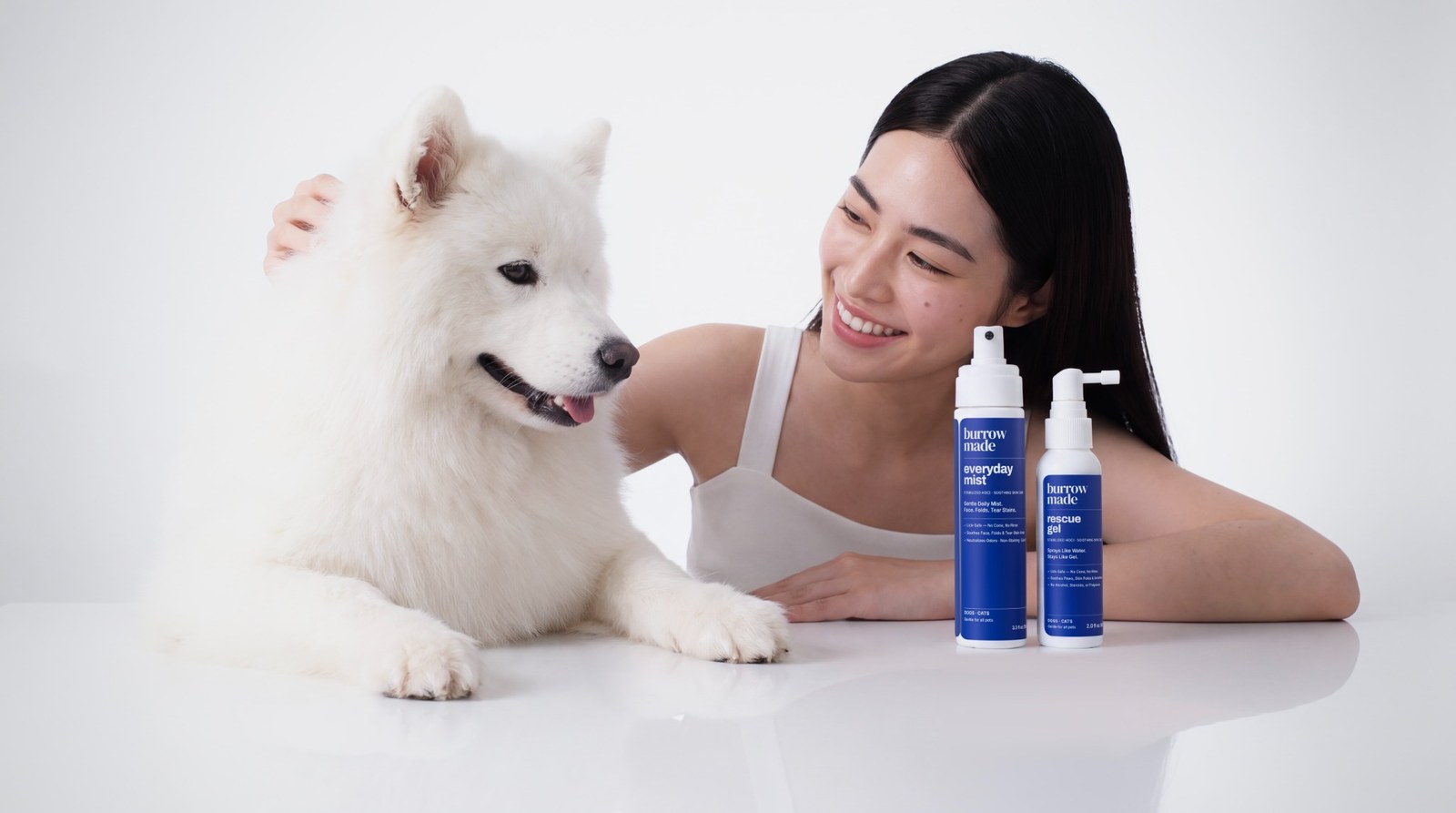 A woman with a white dog beside Burrow Made Everyday Mist and Rescue Gel.